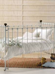 classic-baby-crib-with-metal-cage-white-sheets-small-dolls-and-rug